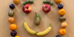 Aus verschiedenen Obstorten wurde ein Gesicht gelegt (Bananen als Mund, Äpfel als Augen etc.).